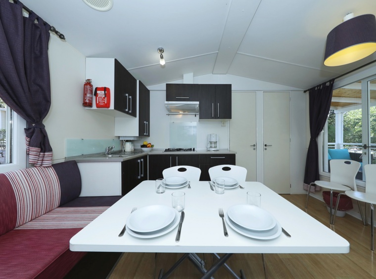 Blagovaonica mobilne kućice s kuhinjom i postavljenim stolom