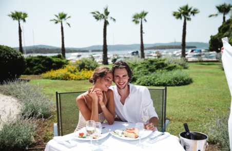 Moški in ženska sedita za mizo na prostem in uživata v sladici