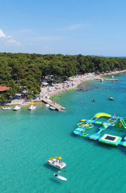 zračni pogled na plažo z napihljivim vodnim parkom v morju