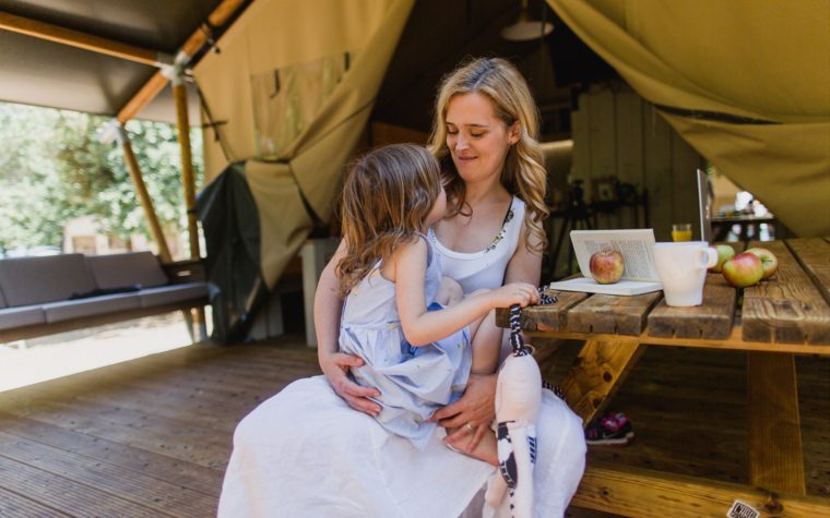 Mama in otrok sedita za mizo v glamping šotoru